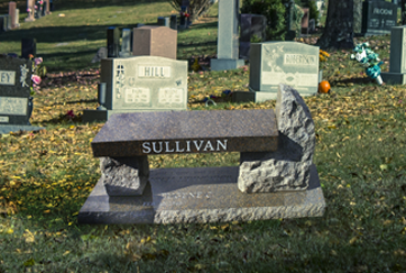 Bench with larger and smaller stone for supports and last name "Sullivan"